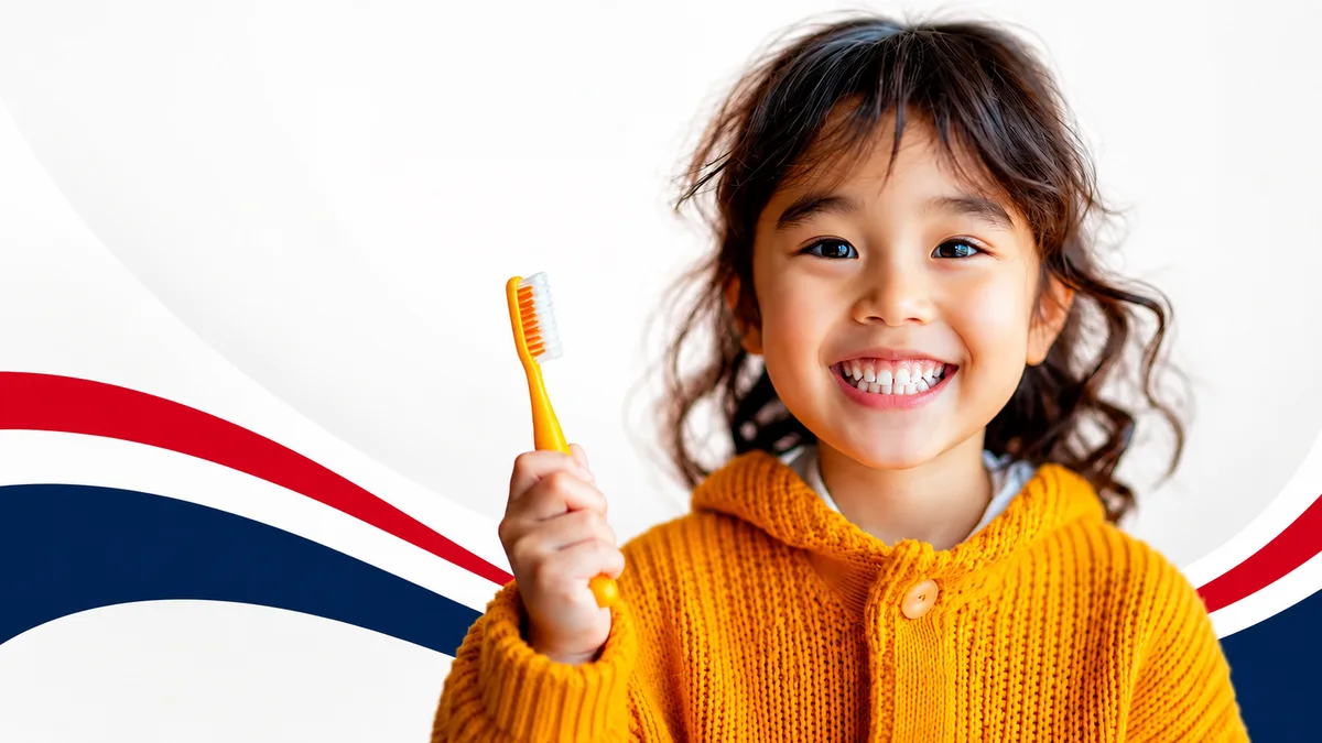A smiling child holding a toothbrush at Akron Family Dental